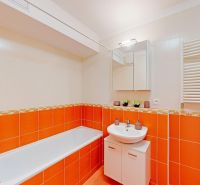 Zrekonštruovaný 2i byt s lodžiou, klimatizáciou, park., Jégeho alej - Kúpeľňa v 2-izbovom byte s oranžovo-bielymi obkladmi, vaňou a umývadlom.