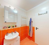Zrekonštruovaný 2i byt s lodžiou, klimatizáciou, park., Jégeho alej - Kúpeľňa v 2-izbovom byte so svetlou sanitou a oranžovými obkladmi.