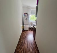 2 izbový byt na prenájom s balkónom na Kalinčiakovej, voľný od 01.10.2 - Úzka chodba s podlahou s dreveným dekorom vedie do kuchyne v 2-izbovom byte.