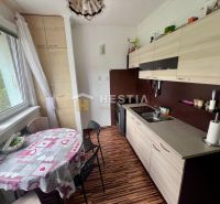 2 izbový byt na prenájom s balkónom na Kalinčiakovej, voľný od 01.10.2 - Kuchyňa v 2-izbovom byte s podlahou s dreveným dekorom a jedálenským stolom.