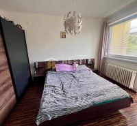 2 izbový byt na prenájom s balkónom na Kalinčiakovej, voľný od 01.10.2 - Spálňa v 2-izbovom byte s podlahou s dreveným dekorom a veľkým oknom.