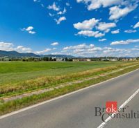 Investičná príležitosť: Komerčný pozemok 8 861 m² s platnou ÚPI v Hlin - Hliník nad Hronom, Pozemky - komerčné, zelené lúk pri ceste obklopenej kopcami a budovami.