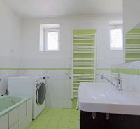 TOP - Rodinný dom v mestskej časti mesta BYTČA - Kúpeľňa v rodinnom dome s vaňou, práčkou a umývadlom v bielozelených tónoch.