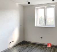 Krásny 1 izbový byt  45m2 + garáž - Jednoduchá miestnosť v 1-izbovom byte s podlahou s dreveným dekorom a bielymi stenami.