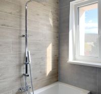 Krásny 1 izbový byt  45m2 + garáž - Kúpeľňa s vaňou a sprchou, obklad s dreveným dekorom, veľké okno, 1-izbový byt.