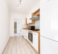 Na prenájom zariadený 4-izbový byt s balkónom I Ružinov |  - Kuchyňa so spotrebičmi a podlahou s dreveným dekorom v 4-izbovom byte.