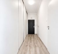 Na prenájom zariadený 4-izbový byt s balkónom I Ružinov |  - Chodba s podlahou s dreveným dekorom a bielymi stenami v 4-izbovom byte.