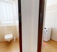 3izbový byt prenájom, 99 m2, Petržalka, Bratislava 5 - Kúpeľňa v 3-izbovom byte s WC, práčkou a podlahou s dreveným dekorom.