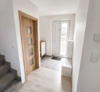 : Moderný rodinný dom Kendice na predaj - Interiér rodinného domu s podlahou s dreveným dekorom, schodiskom a drevenými dverami.
