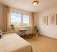 Pekný zariadený 3-izbový byt s 2 balkónmi | 85,3 m² | Petržalka I - Svetlá izba s posteľou, písacím stolom a podlahou s dreveným dekorom.