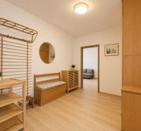 Pekný zariadený 3-izbový byt s 2 balkónmi | 85,3 m² | Petržalka I - Interiér 3-izbového bytu s podlahou s dreveným dekorom, lavicou a zrkadlom.