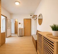 Pekný zariadený 3-izbový byt s 2 balkónmi | 85,3 m² | Petržalka I - Chodba s podlahou s dreveným dekorom a dreveným nábytkom v 3-izbovom byte.