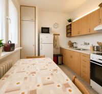 Pekný zariadený 3-izbový byt s 2 balkónmi | 85,3 m² | Petržalka I - Kuchyňa v 3-izbovom byte s linkou, stolom, chladničkou a dekoračnými prvkami.