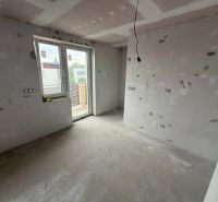 Ponúkame na predaj Rodinný dom v Rovinke na Platanovej ulici - Izba v rodinnom dome počas rekonštrukcie, s betónovou podlahou a veľkým oknom na stenu.