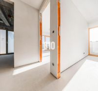 BRATISLAVA NA DLANI - SKOLAUDOVANÝ BYT S TERASOU, NA NAJVYŠŠOM POSCHOD - Priestranný interiér neukončeného 3-izbového bytu s veľkými oknami a betónovým stropom.