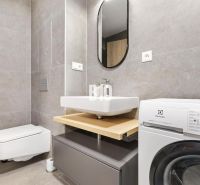 DOWNTOWN NA DOSAH – DIZAJNOVÝ 1-izbový apartmán s loggiou a výhľadom n - Kúpeľňa v 1-izbovom byte s modernou práčkou a sivým obkladom.