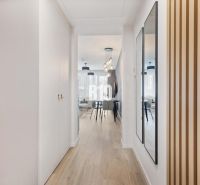 DOWNTOWN NA DOSAH – DIZAJNOVÝ 1-izbový apartmán s loggiou a výhľadom n - Chodba s podlahou s dreveným dekorom, zrkadlom a vstupom do obývacej časti.