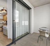 DOWNTOWN NA DOSAH – DIZAJNOVÝ 1-izbový apartmán s loggiou a výhľadom n - Balkón s posedením a výhľad do 1-izbového bytu cez posuvné dvere.