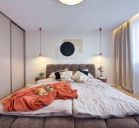 Moderný 3 izbový byt s balkónom a výhľadom na Zobor - Chrenová - Spálňa v 3-izbovom byte s posteľou, závesmi a skriňou; podlaha s dreveným dekorom.