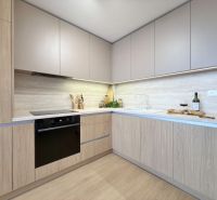 Moderný 3 izbový byt s balkónom a výhľadom na Zobor - Chrenová - Kuchyňa v 3-izbovom byte s podlahou s dreveným dekorom a zabudovanými spotrebičmi.