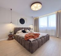 Moderný 3 izbový byt s balkónom a výhľadom na Zobor - Chrenová - Svetlá spálňa s veľkou posteľou a podlahou s dreveným dekorom v 3-izbovom byte.