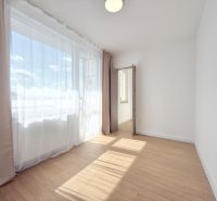 Moderný 3 izbový byt s balkónom a výhľadom na Zobor - Chrenová - Svetlá izba so závesmi a podlahou s dreveným dekorom v 3-izbovom byte.