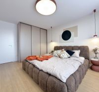 Moderný 3 izbový byt s balkónom a výhľadom na Zobor - Chrenová - Spálňa v 3-izbovom byte s veľkou posteľou a podlahou s dreveným dekorom.