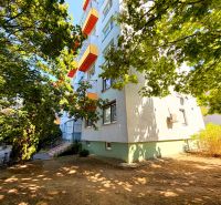 Na predaj kompletne prerobený 1 izbový byt, Vráble - Lúky, 36m2, 7/7 - Bytovka s farebnými balkónmi na ulici Lúky vo Vrábľoch, obklopená stromami.
