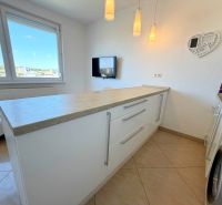Na predaj kompletne prerobený 1 izbový byt, Vráble - Lúky, 36m2, 7/7 - Kuchyňa v 1-izbovom byte s práčkou, bielymi skrinkami a pracovnou doskou.