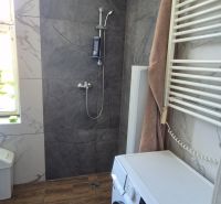 Na predaj 2 izbový tehlový byt 45m2 - Nové Zámky  - Kúpeľňa v 2-izbovom byte s práčkou, sprchou a podlahou s dreveným dekorom.