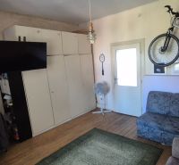 Na predaj 2 izbový tehlový byt 45m2 - Nové Zámky  - Obývacia izba 2-izbového bytu so sedačkou, televízorom a bicyklom na stene.