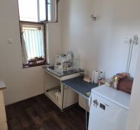Na predaj 2 izbový tehlový byt 45m2 - Nové Zámky  - Kuchyňa v 2-izbovom byte so spotrebičmi a podlahou s dreveným dekorom.