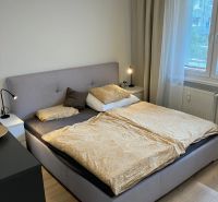 Prenájom pekný 3 izbový byt, ulica Staré záhrady,Bratislava II-Ružinov - Spálňa s veľkou posteľou, nočnými stolíkmi a podlahou s dreveným dekorom v 3-izbovom byte.