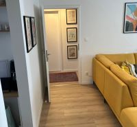 Prenájom pekný 3 izbový byt, ulica Staré záhrady,Bratislava II-Ružinov - Svetlá podlaha s dreveným dekorom a žltá pohovka v 3-izbovom byte.