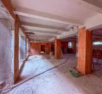 Industriálny obchodný priestor v úplnom centre mesta - 137 m2 - Obchodné priestory vo výstavbe s odkrytými stenami a stĺpmi, surový betónový povrch.