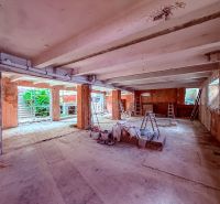 Industriálny obchodný priestor v úplnom centre mesta - 137 m2 - Rozostavané obchodné priestory s betónovou podlahou, rebríkmi a stavebným materiálom.