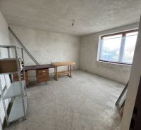 Rozostavaný rodinný dom Plavnica - Nedokončená miestnosť v Rodinnom dome s oknom a kovovým regálom.