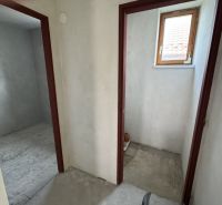 Rozostavaný rodinný dom Plavnica - V Rodinnom dome sa nachádzajú dve miestnosti s betónovou podlahou a malým oknom.