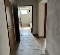Rozostavaný rodinný dom Plavnica - Chodba v rodinnom dome s dlažbou a oknom, bez viditeľného nábytku.