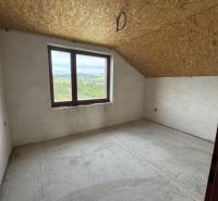 Rozostavaný rodinný dom Plavnica - Pohľad do prázdnej miestnosti rodinného domu so strešným oknom a betónovou podlahou.