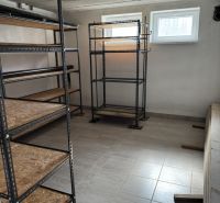Rozostavaný rodinný dom Plavnica - Sklad s kovovými regálmi a dlažbou v rodinnom dome.