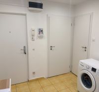 2,5 izbový byt v centre Lučenca - Vstupná chodba v 2-izbovom byte so žltou dlažbou a práčkou.