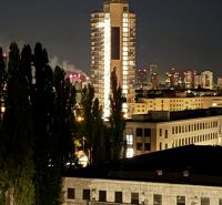 PENTHOUSE – moderný 2i byt s výnimočnou 69 m² terasou, AHOJ PARK - Večerný pohľad na osvetlený výškový dom v Bratislave, Novom Meste na Sliačskej ulici.