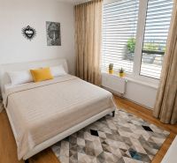 PENTHOUSE – moderný 2i byt s výnimočnou 69 m² terasou, AHOJ PARK - Spálňa v 2-izbovom byte s podlahou s dreveným dekorom, harmonickým interiérom a dekoráciou.