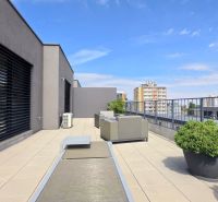 PENTHOUSE – moderný 2i byt s výnimočnou 69 m² terasou, AHOJ PARK - Terasa 2-izbového bytu na Sliačskej ulici v Bratislave - Nové Mesto so zeleňou a nábytkom.