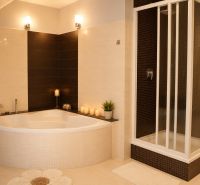 Dvojgeneračný RD s veľkým pozemkom a potenciálom ďalšej výstavby - Elegantná kúpeľňa s rohovou vaňou, sprchovacím kútom a jemným osvetlením v rodinnom dome.