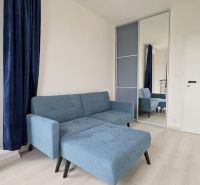 MODERNÝ 3i BYT, NOVOSTAVBA ČEREŠNE, LOGGIA, KLÍMA, PARKING, Polianky - Modrá pohovka v 3-izbovom byte s podlahou s dreveným dekorom a zrkadlovou skriňou.