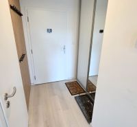 MODERNÝ 3i BYT, NOVOSTAVBA ČEREŠNE, LOGGIA, KLÍMA, PARKING, Polianky - Vstupná chodba s bielymi dverami, dreveným vešiakom a šatníkovou skriňou v 3-izbovom byte.