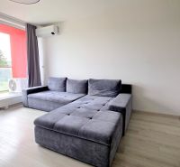 MODERNÝ 3i BYT, NOVOSTAVBA ČEREŠNE, LOGGIA, KLÍMA, PARKING, Polianky - Obývačka v 3-izbovom byte so sivou sedačkou a podlahou s dreveným dekorom.