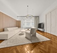  EXKLUZÍVNY, VEĽKOMETRÁŽNY 3i byt ( 130 m2 ), REKONŠTRUKCIA, CENTRUM - Priestranná obývačka v 3-izbovom byte s podlahou s dreveným dekorom a pohodlným sedením.